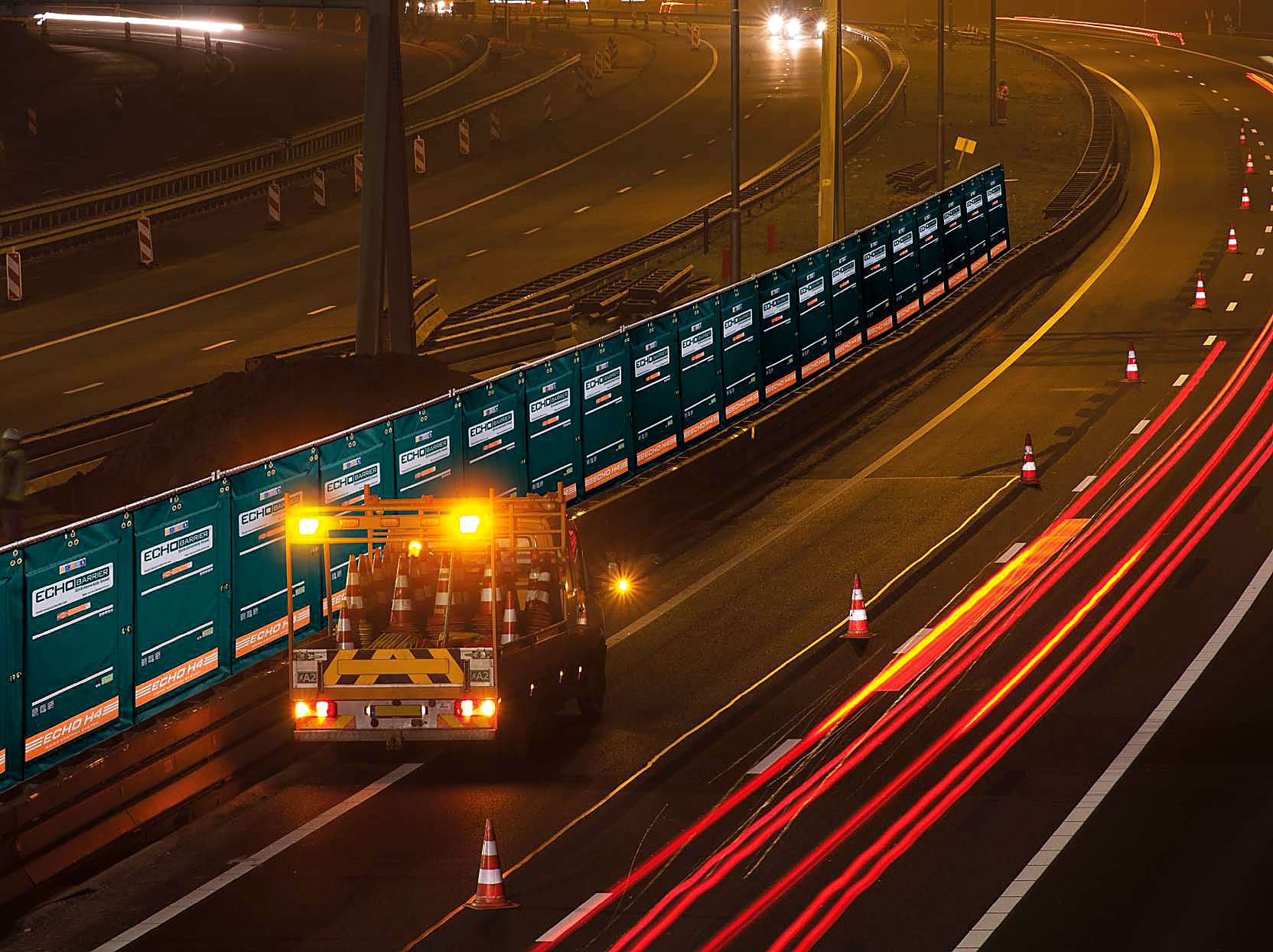 Echo Barrier outdoor acoustic panels deployed along highway at night