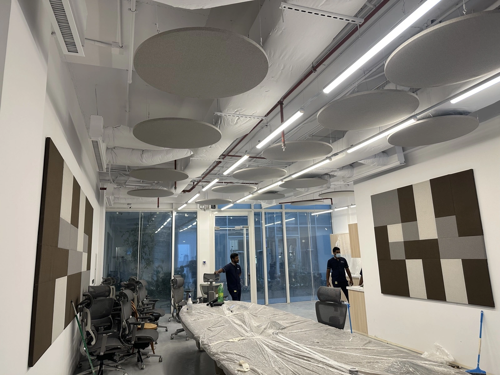 HungerStation HQ — office overview with circular baffles and wall panels