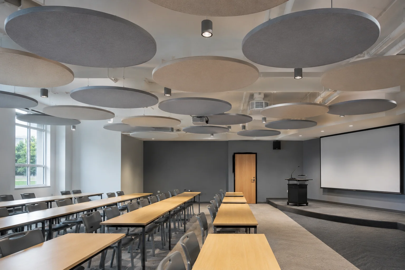 Circular fabric baffles in café / lounge — warm wooden interior with blue and neutral tones