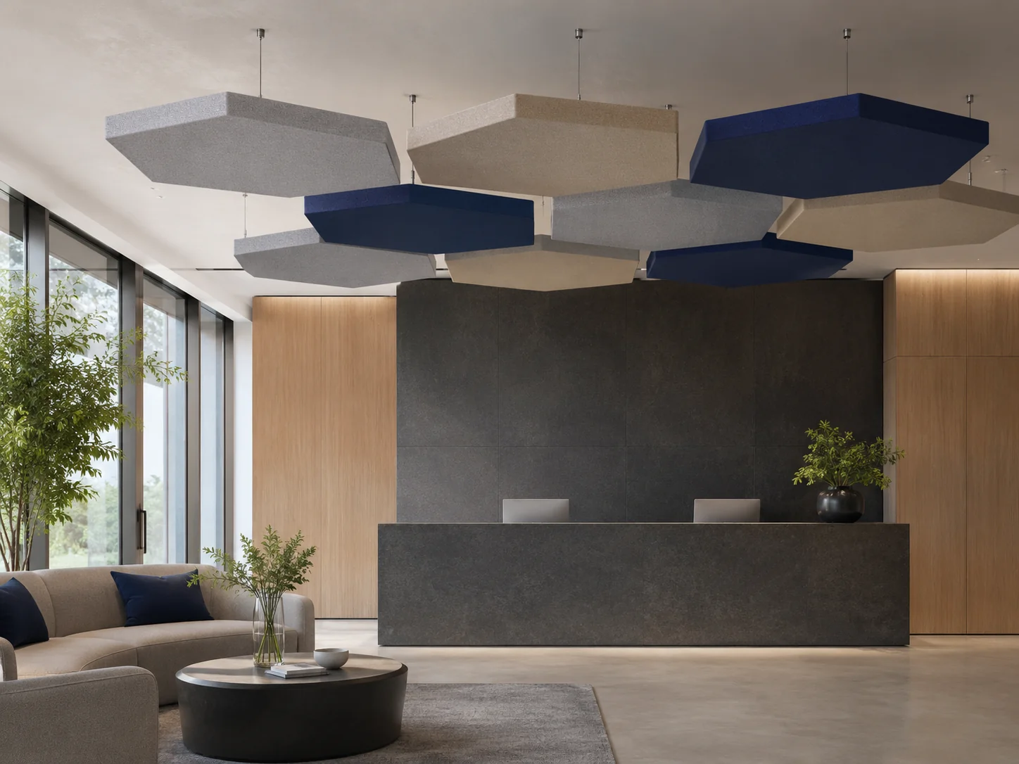 Hexagon fabric baffles above reception lobby — tessellated grey, navy, and beige cluster with wood and dark stone